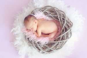newborn baby girl sleeping in a basket
