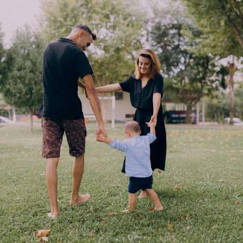 health and wellbeing: parents playing with their child in a park