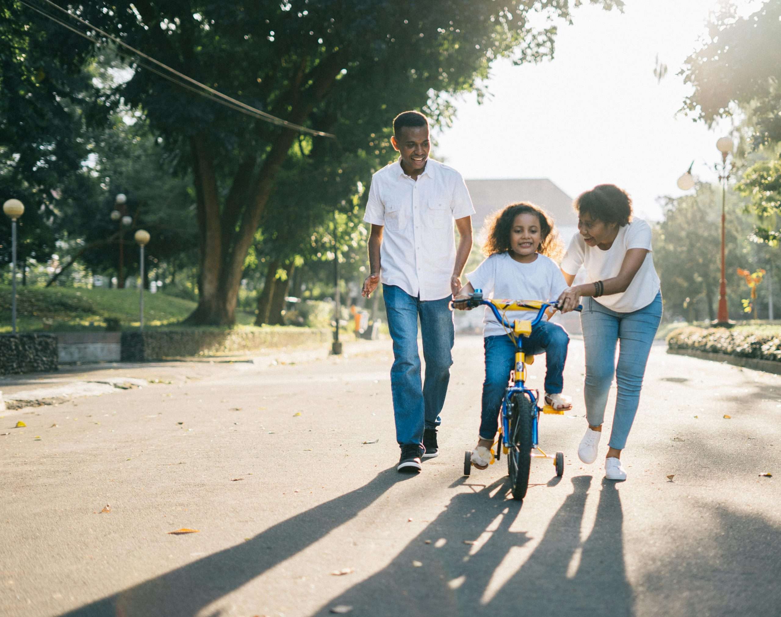 health and wellbeing: parents teaching their child to ride a bike