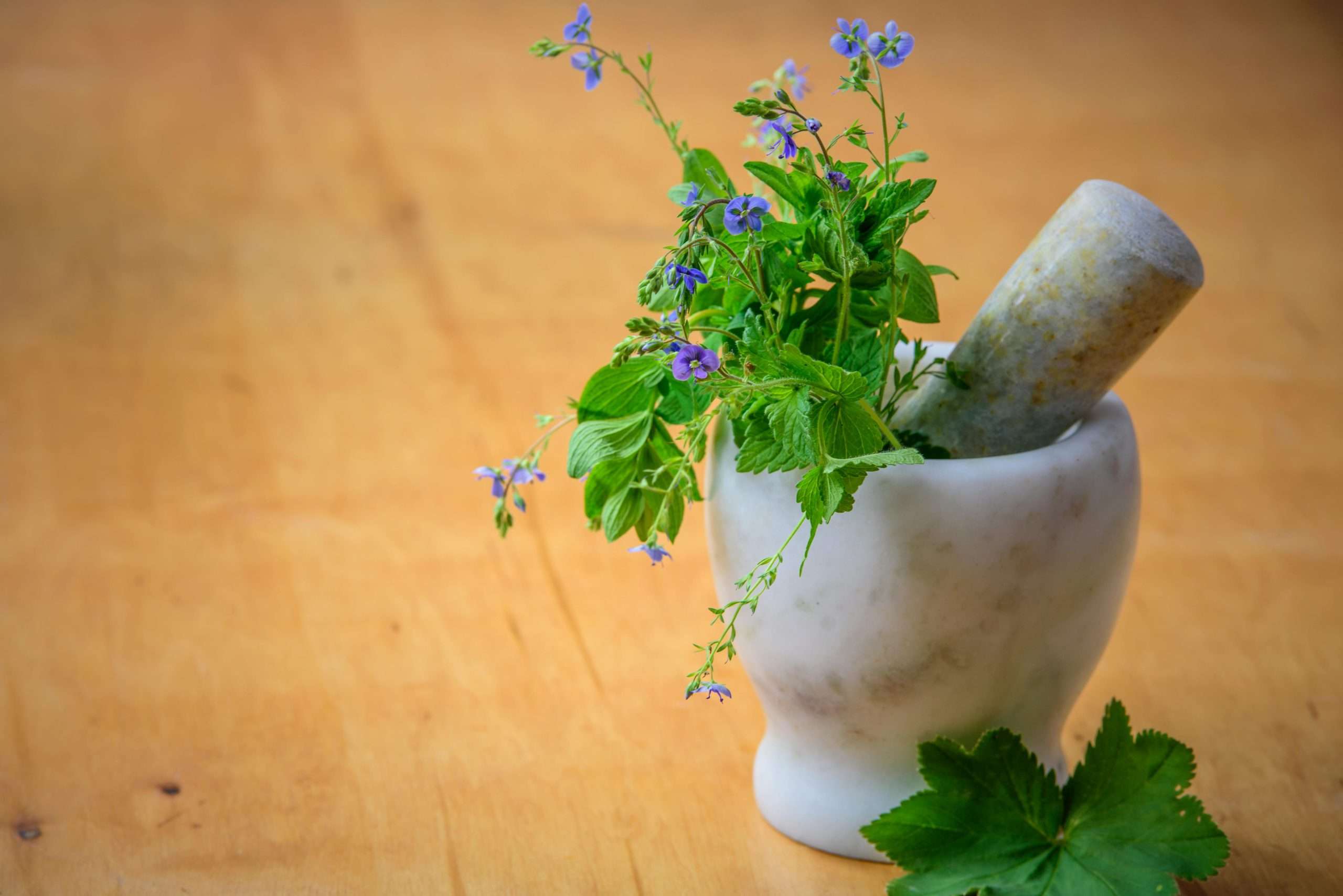 hydrogen water and purple flowers in a mortar and pestle