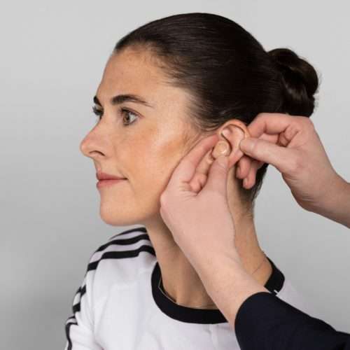 hearing loss - woman getting fitted for a hearing aid