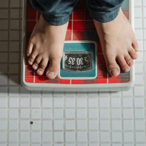 weighing on a scale - skin removal after extreme weight loss
