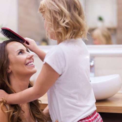 child brushing moms hair