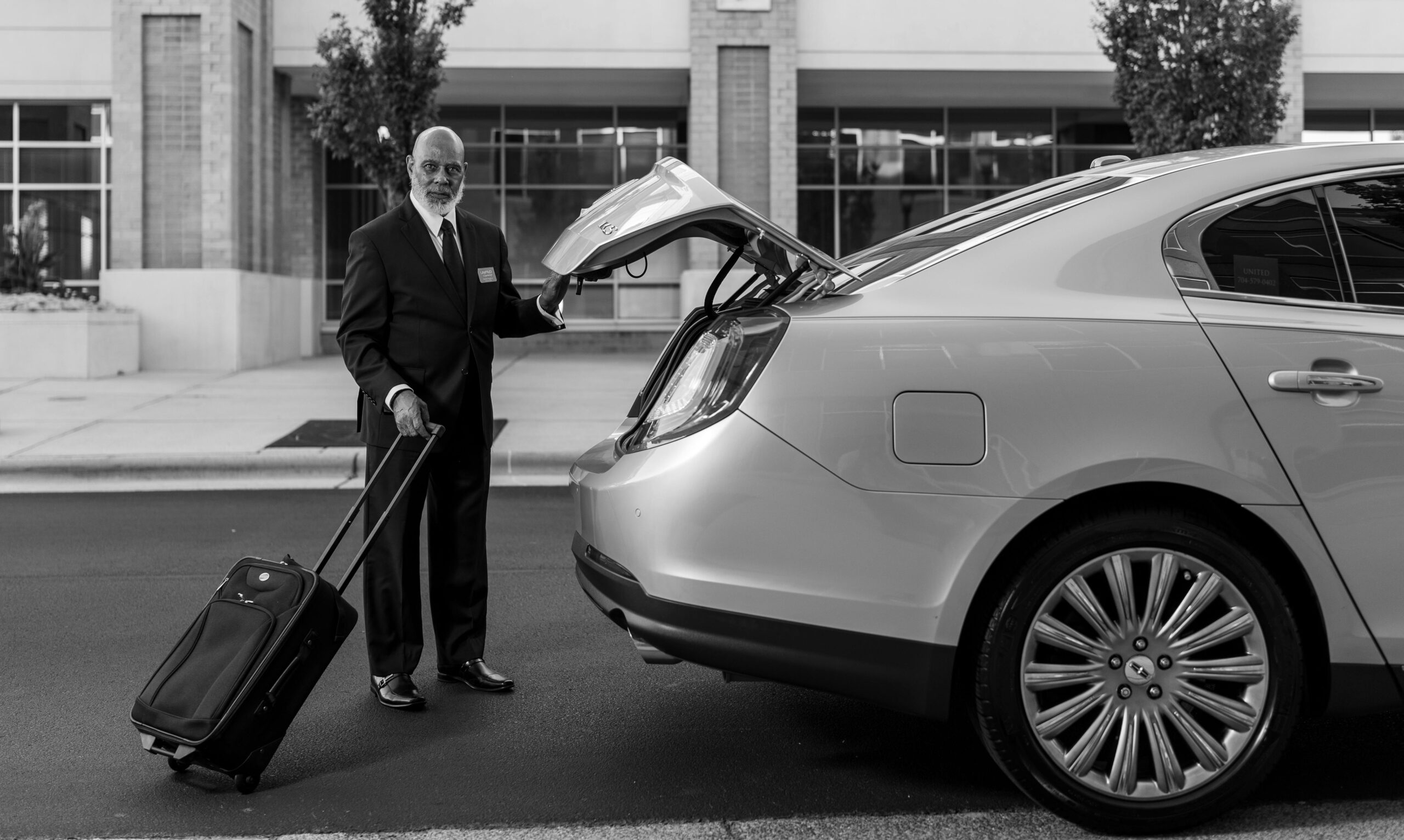 a professional chauffeur with a luxury sedan - transportation services