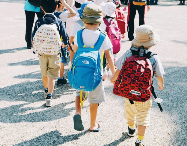 children wearing backpacks