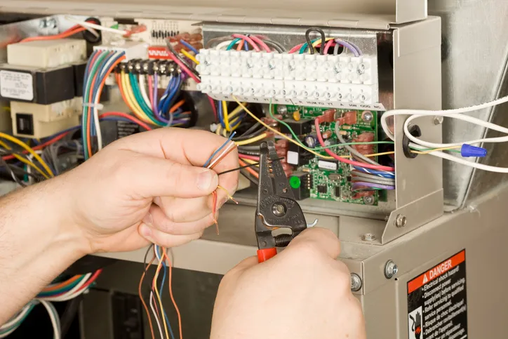 Comprehensive HVAC Services - technician checking electrical connections